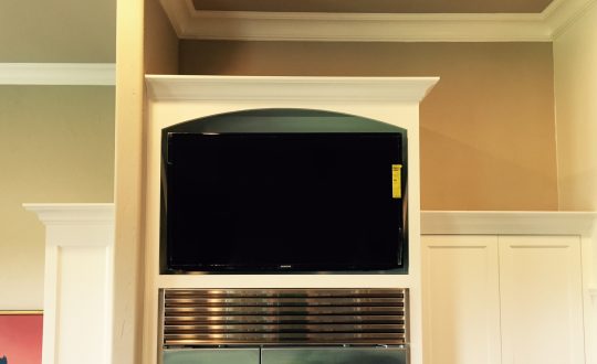 TV Mounted above refrigerator in kitchen
