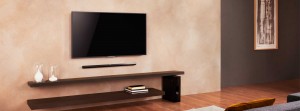 Soundbar mounted below TV with sub-woofer placed next to console